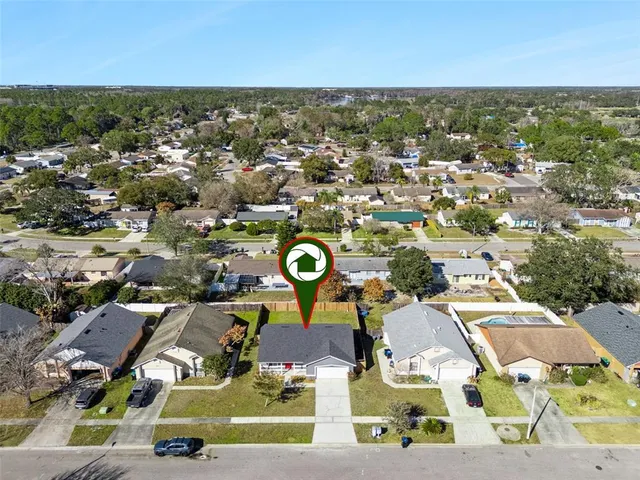 an aerial view of residential houses with outdoor space and parking
