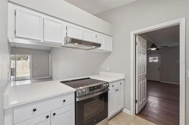 a kitchen with white cabinets and appliances