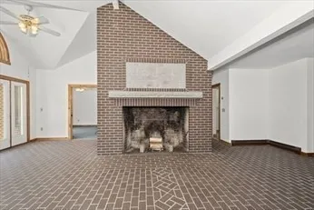 a view of empty room with wooden floor and fireplace