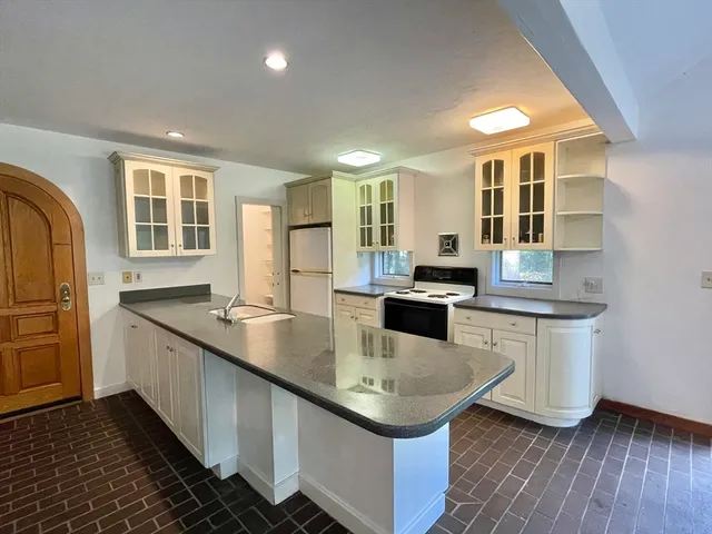 a open kitchen with granite countertop a sink and dishwasher a stove top oven with wooden floor