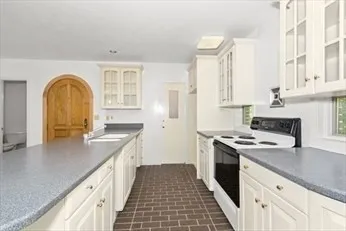 a view of a hall with wooden floor and a fireplace
