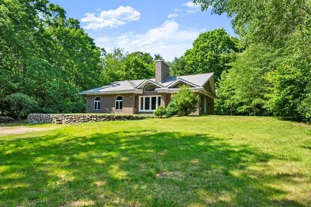 a front view of a house with yard and green space