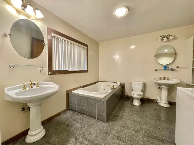 a bathroom with a double vanity sink a mirror and a bathtub