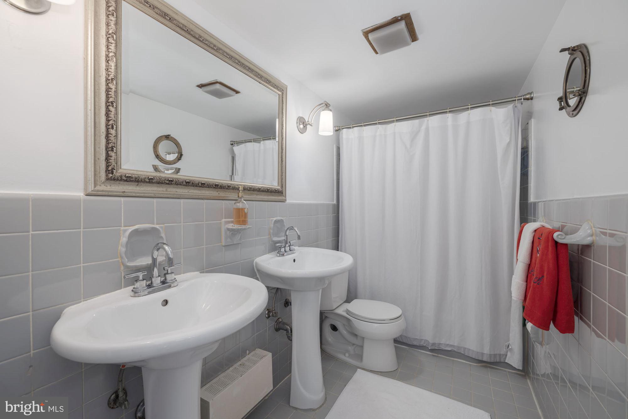 4201 Cathedral Avenue Northwest, Unit 620E Washington, DC 20016 - Photo 11 of 28 a bathroom with a sink toilet and mirror
