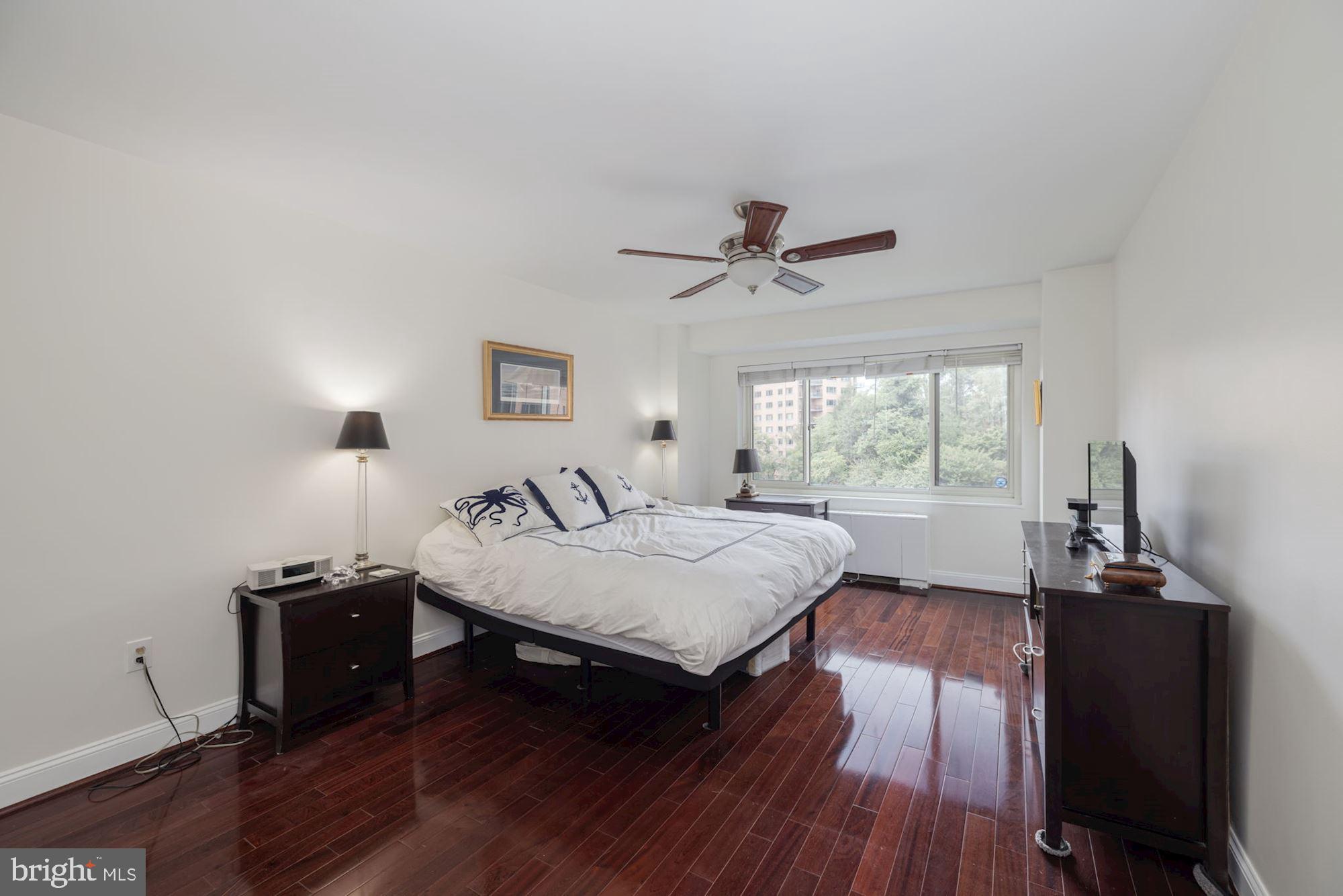 4201 Cathedral Avenue Northwest, Unit 620E Washington, DC 20016 - Photo 12 of 28 a bedroom with a bed and wooden floor