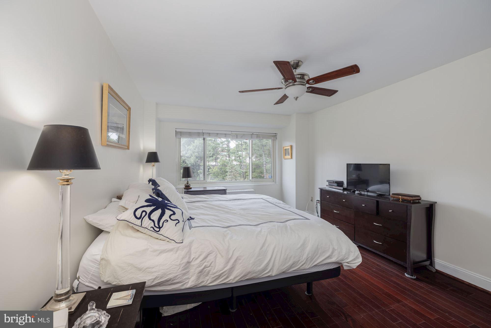 4201 Cathedral Avenue Northwest, Unit 620E Washington, DC 20016 - Photo 13 of 28 a bedroom with a bed and a flat tv screen on the dresser