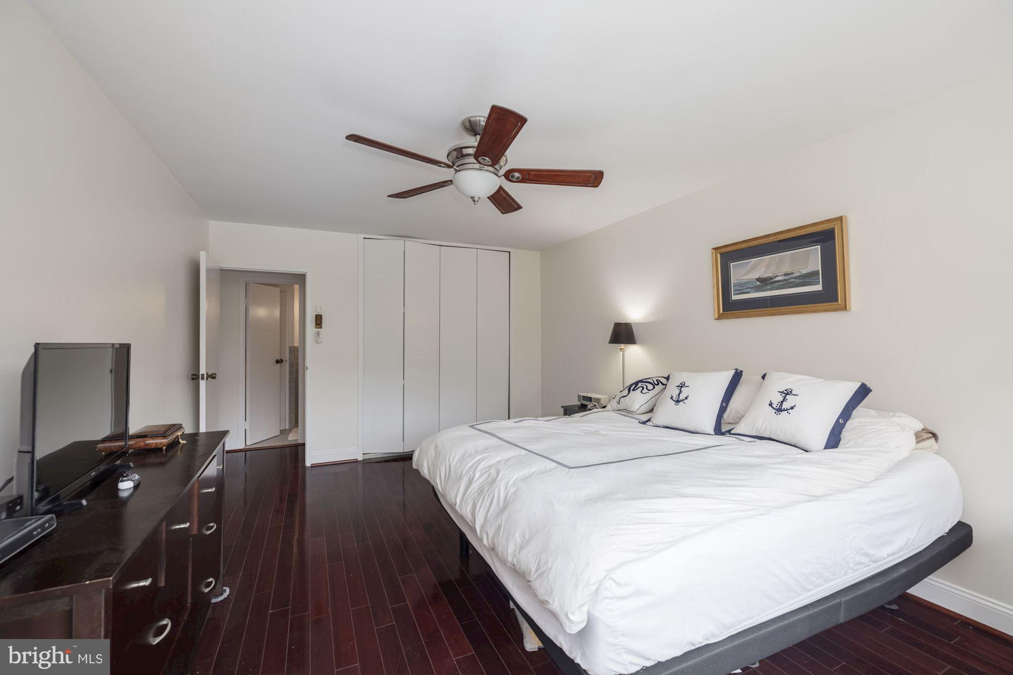 4201 Cathedral Avenue Northwest, Unit 620E Washington, DC 20016 - Photo 14 of 28 a bedroom with a bed and wooden floor
