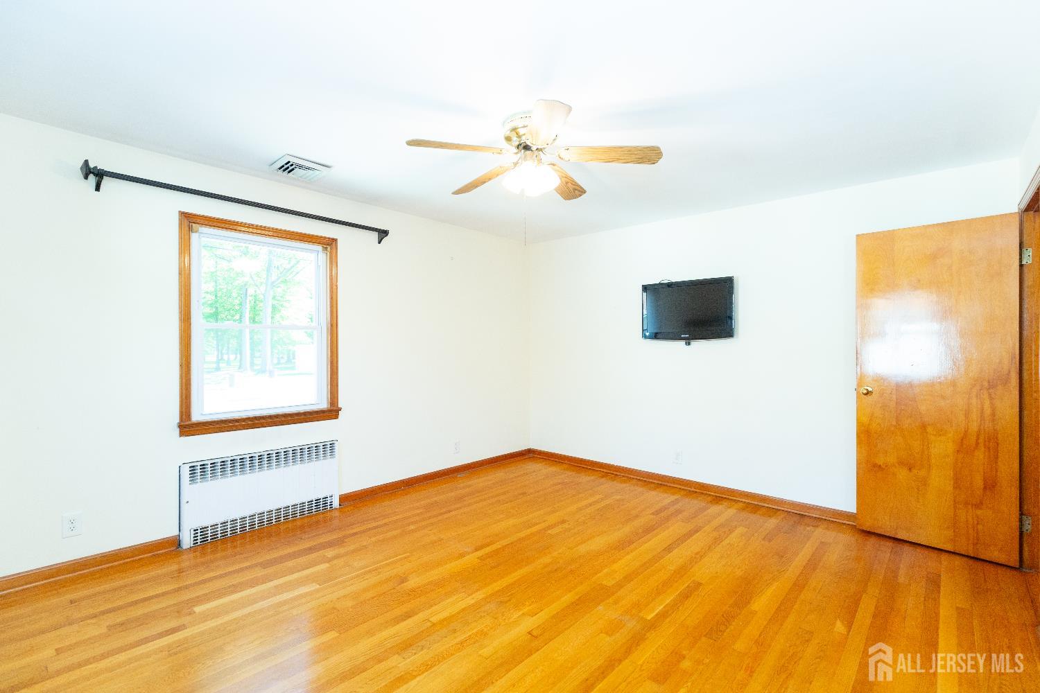 2624 Tremley Point Road Linden, NJ 07036 - Photo 16 of 43 a view of an empty room with wooden floor and a window