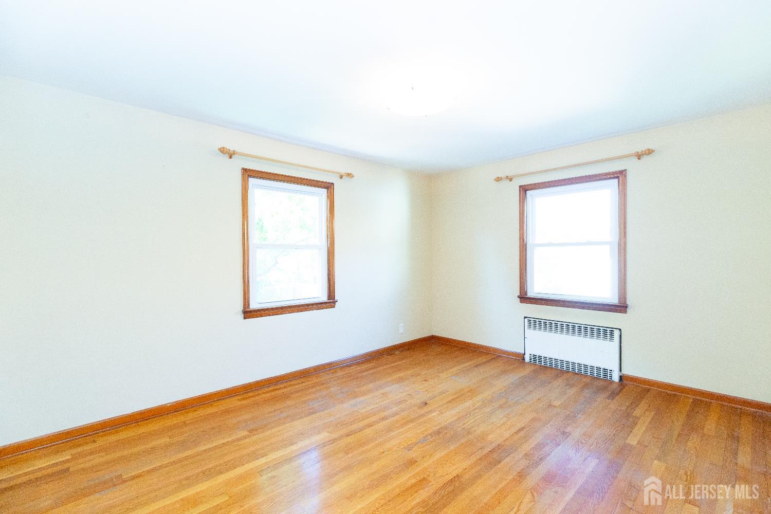 2624 Tremley Point Road Linden, NJ 07036 - Photo 17 of 43 an empty room with wooden floor and windows