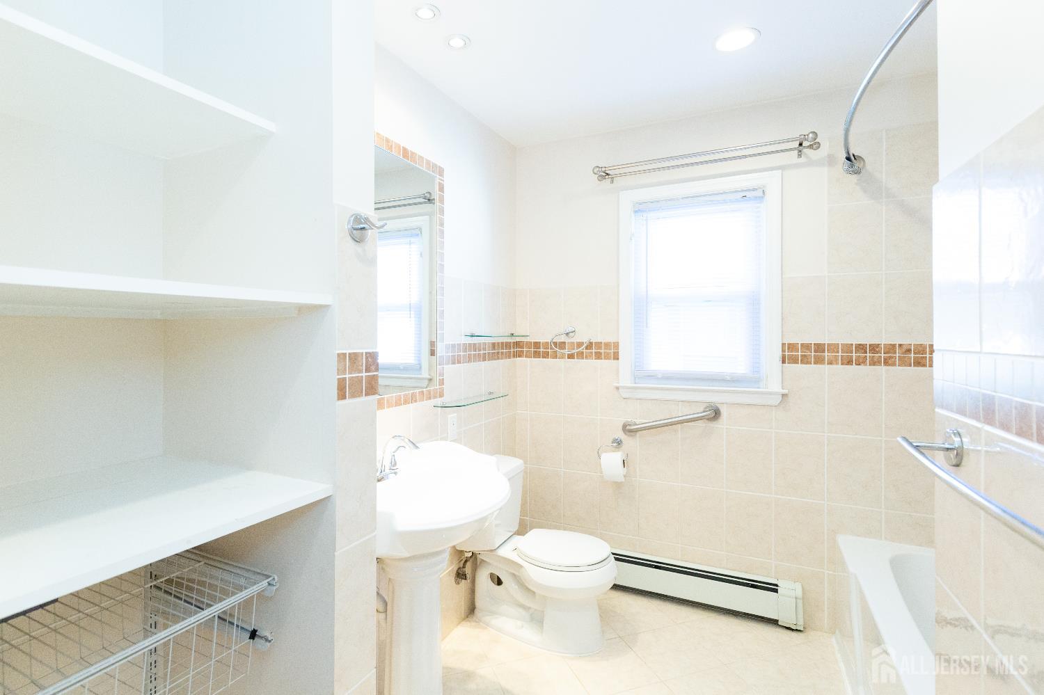 2624 Tremley Point Road Linden, NJ 07036 - Photo 21 of 43 a bathroom with a sink a toilet a vanity and mirror