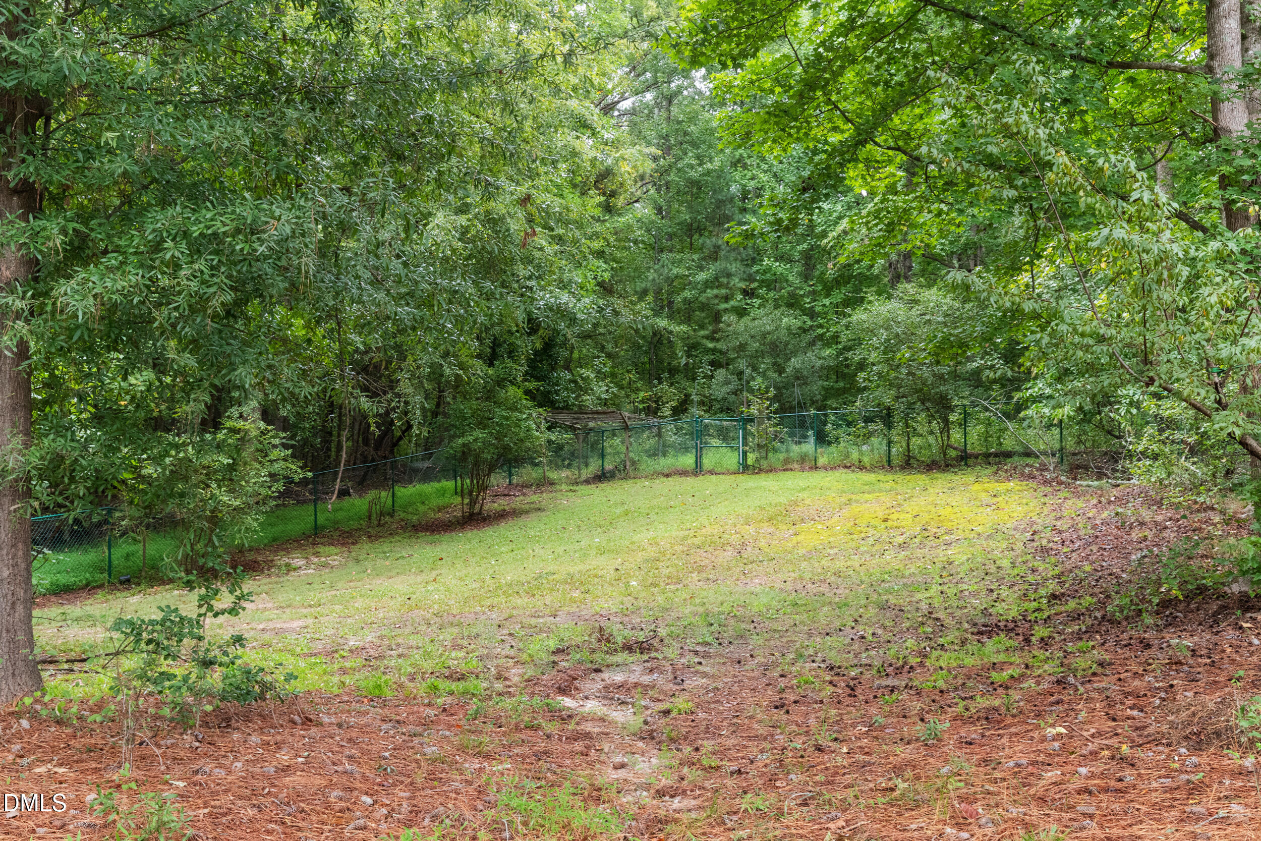 2329 Win Road Garner, NC 27529 - Photo 69 of 90 Expansive yard featuring mature trees, a gently sloped lawn, and perimeter fencing