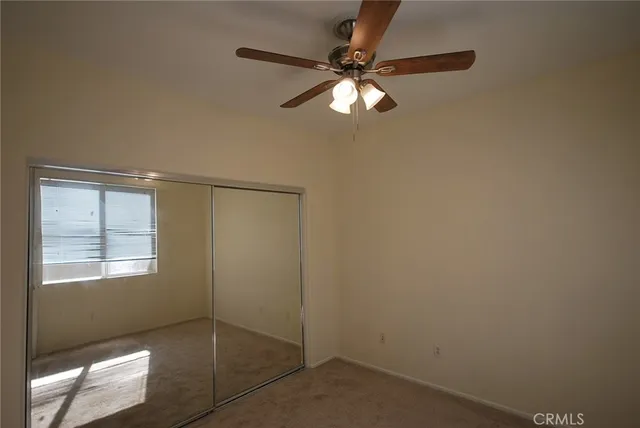 an empty room with windows and fan