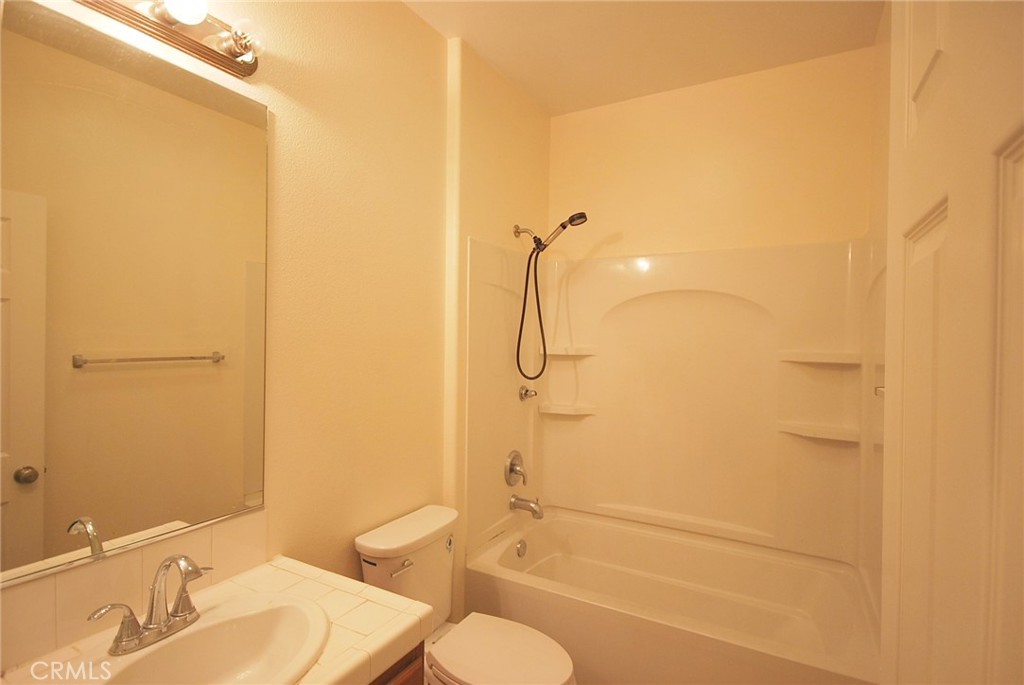 25209 Bishop Court Stevenson Ranch, CA 91381 - Photo 15 of 19 a bathroom with a granite countertop shower sink vanity mirror and toilet