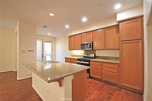 a kitchen with stainless steel appliances granite countertop a sink stove and refrigerator