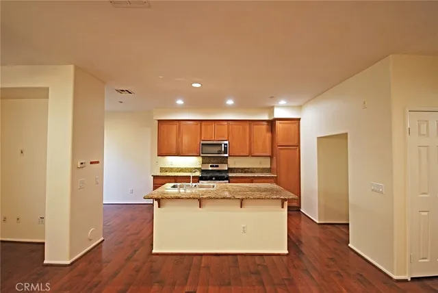 a kitchen with kitchen island a sink and a stove