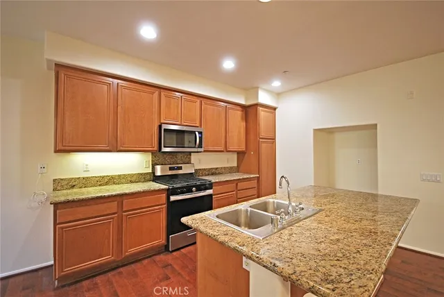 a kitchen with stainless steel appliances granite countertop a sink stove and refrigerator