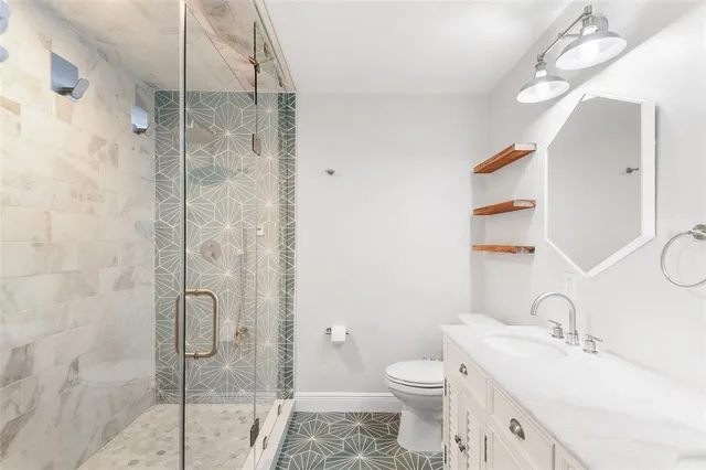 a bathroom with a sink toilet vanity and shower