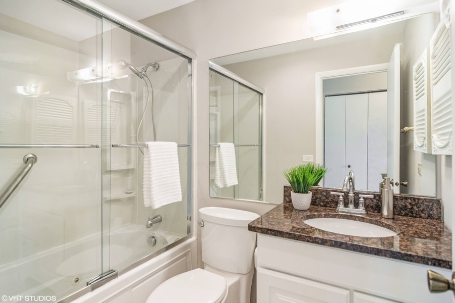 545 Greystone Lane, Unit A2 Wheeling, IL 60090 - Photo 14 of 21 a bathroom with a granite countertop sink a mirror and a shower
