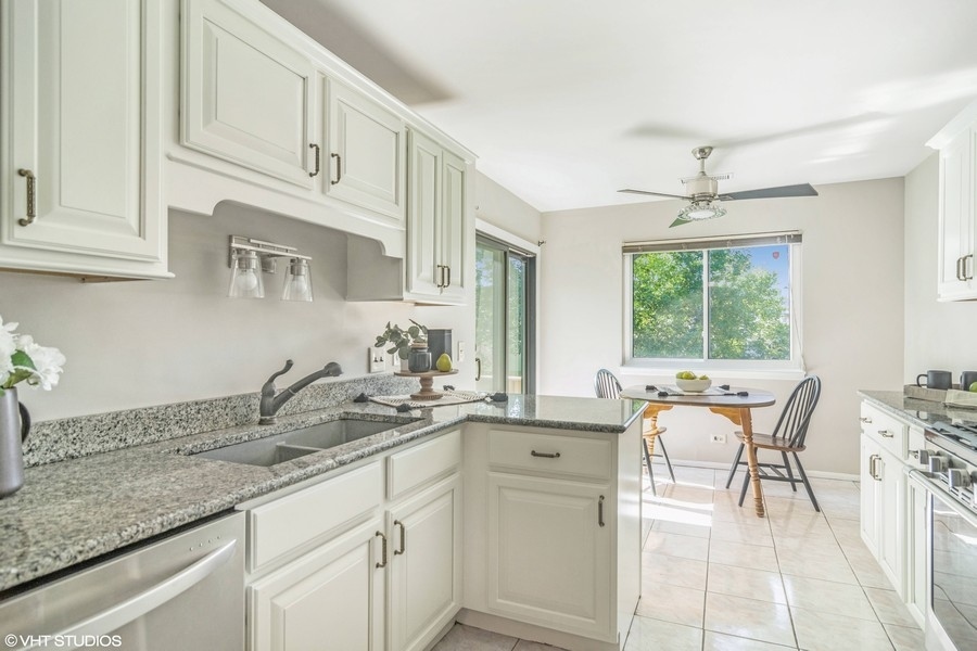 545 Greystone Lane, Unit A2 Wheeling, IL 60090 - Photo 6 of 21 a kitchen with stainless steel appliances granite countertop a sink and cabinets