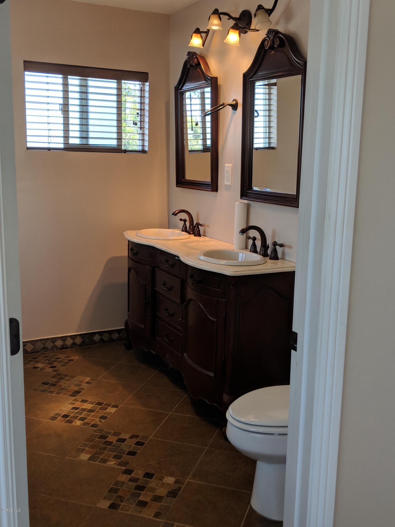 19518 Hart Street Reseda, CA 91335 - Photo 11 of 16 a bathroom with a sink toilet and mirror