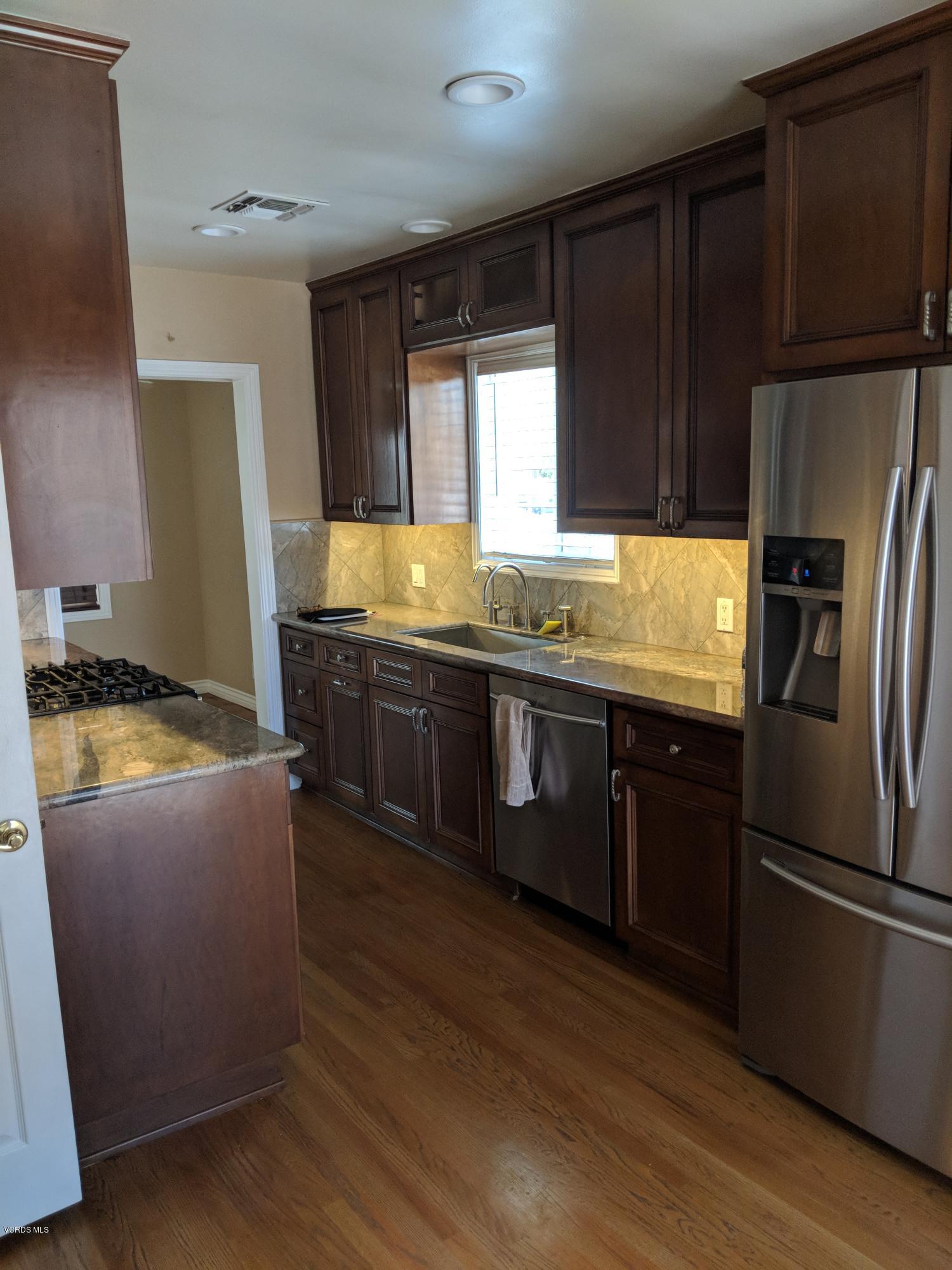 19518 Hart Street Reseda, CA 91335 - Photo 6 of 16 a kitchen with stainless steel appliances granite countertop a refrigerator a sink a stove a counter space and cabinets