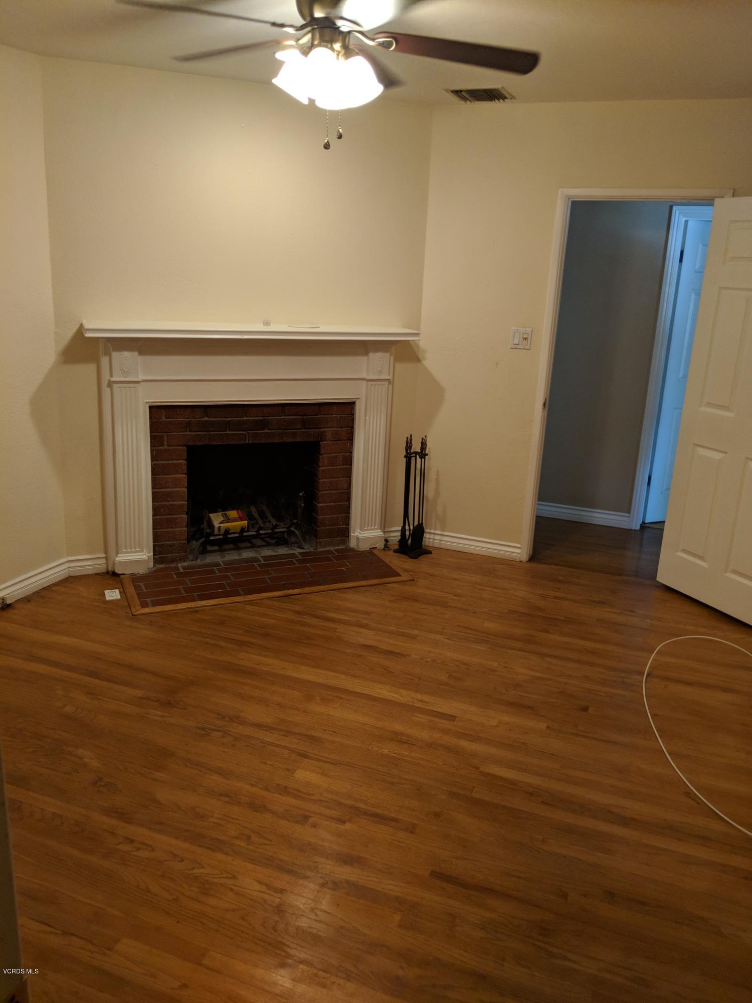 19518 Hart Street Reseda, CA 91335 - Photo 8 of 16 a view of an empty room with wooden floor and a fireplace