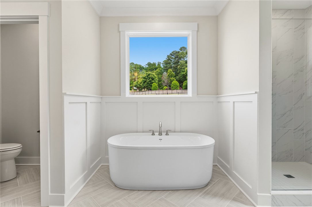 203 Timothy Court Anderson, SC 29621 - Photo 13 of 40 A spacious bathroom boasts a luxurious soaking tub nestled below a sun-filled window, with a separate shower.