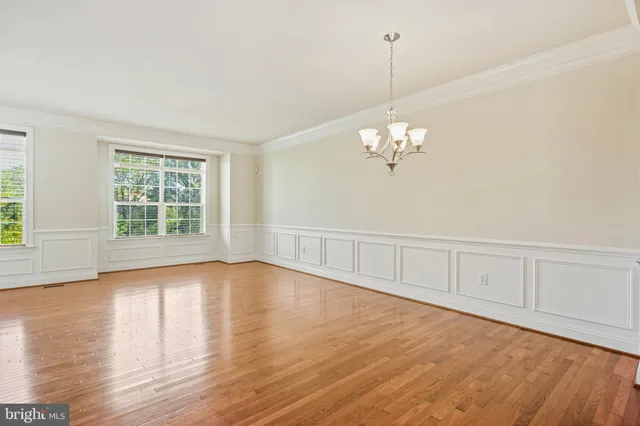 a view of a room with wooden floor and chandelier