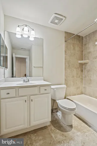 a bathroom with a sink a toilet a mirror a vanity and bathtub