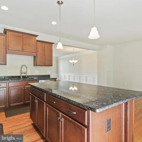a kitchen with granite countertop a sink a counter space appliances and cabinets