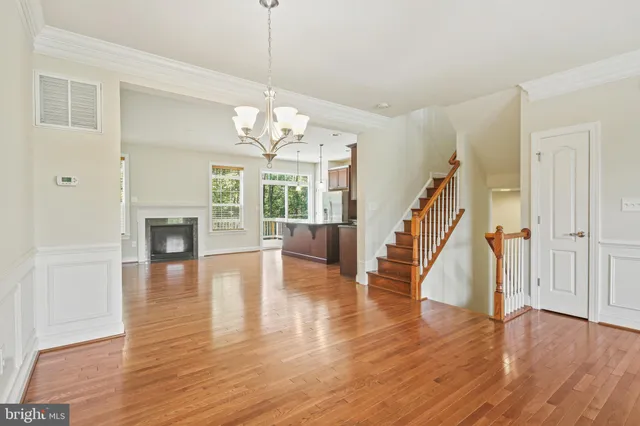 a view of a livingroom with wooden floor and staircase