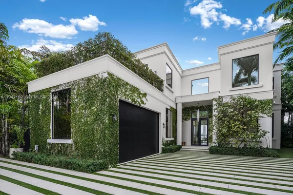 a front view of a house with plants