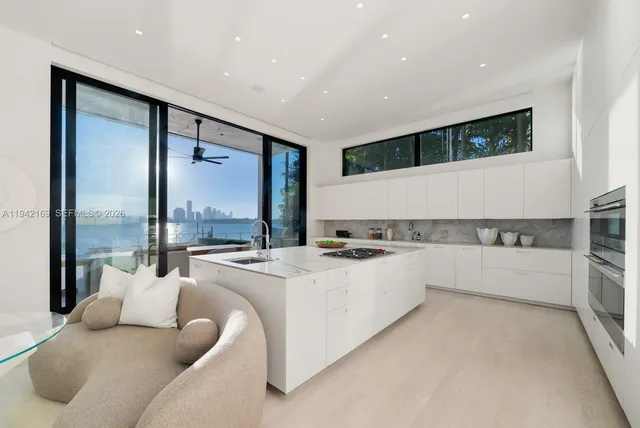 a large white kitchen with a large window
