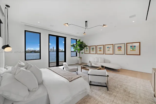 a bedroom with furniture and a large window