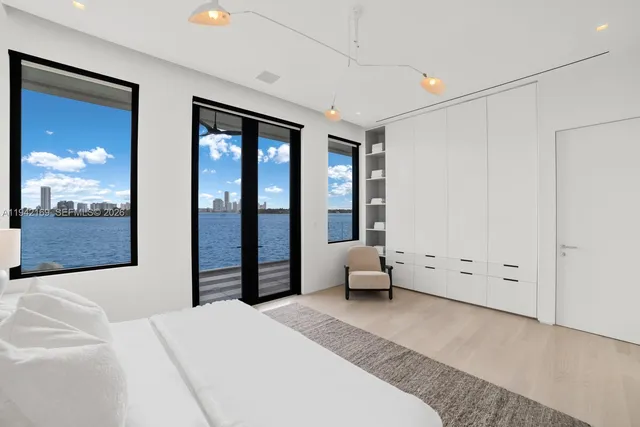 a bedroom with furniture and large windows