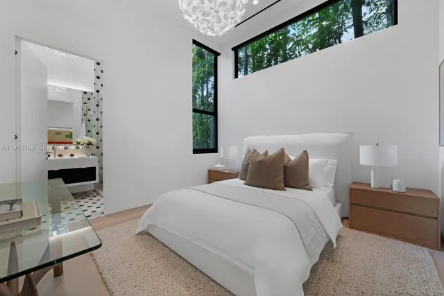 a bedroom with bed a flat tv screen and a dresser