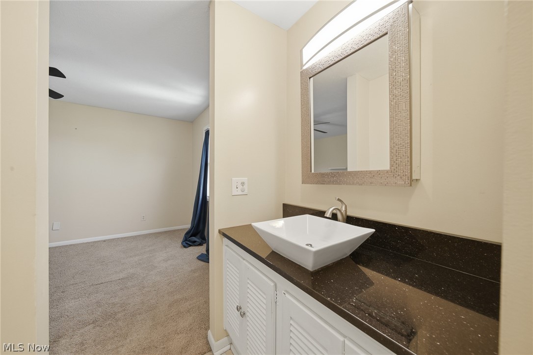 824 South Chillicothe Road, Unit 2 Aurora, OH 44202 - Photo 26 of 42 Bathroom vanity featuring a vessel sink, dark countertop, and brushed nickel faucet