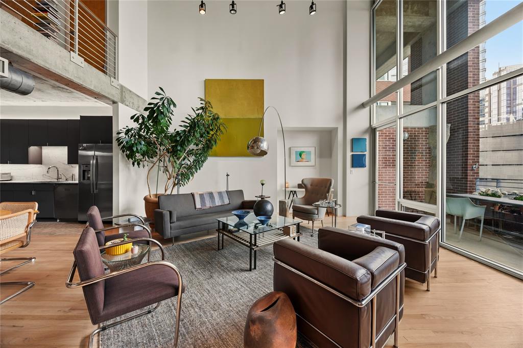 2011 Cedar Springs Road, Unit 305 Dallas, TX 75201 - Photo 11 of 27 Two-story living area with high ceilings, exposed concrete beams, and wood-finish flooring