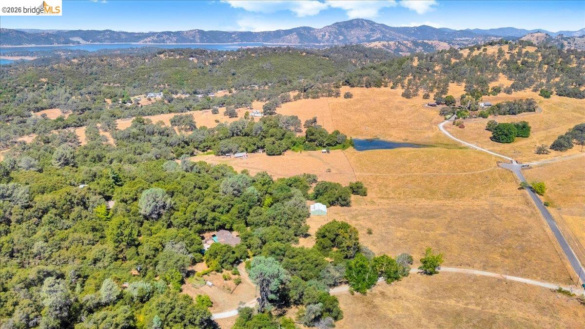 8733 Fraguero Road Sonora, CA 95370 - Photo 64 of 73 Expansive rural property featuring a mix of mature trees, open fields, a private pond, and a paved road