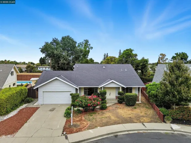 a view of house with garden and tall tress