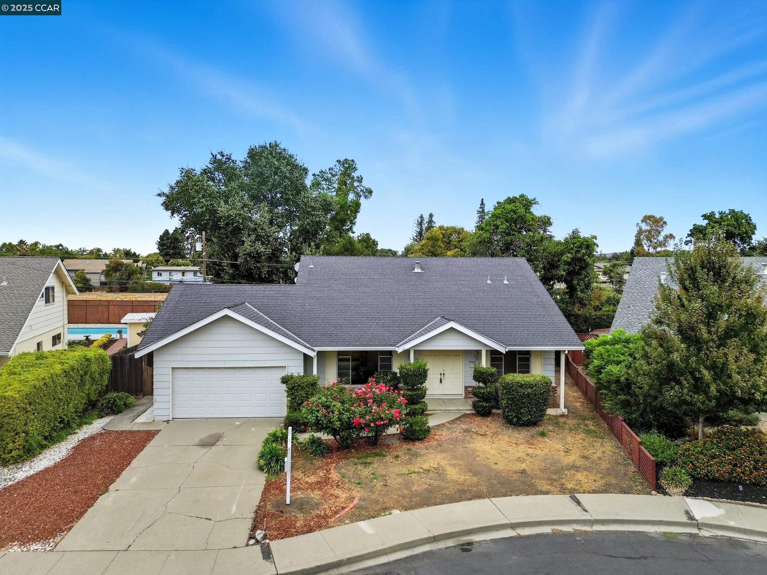 a view of house with garden and tall tress