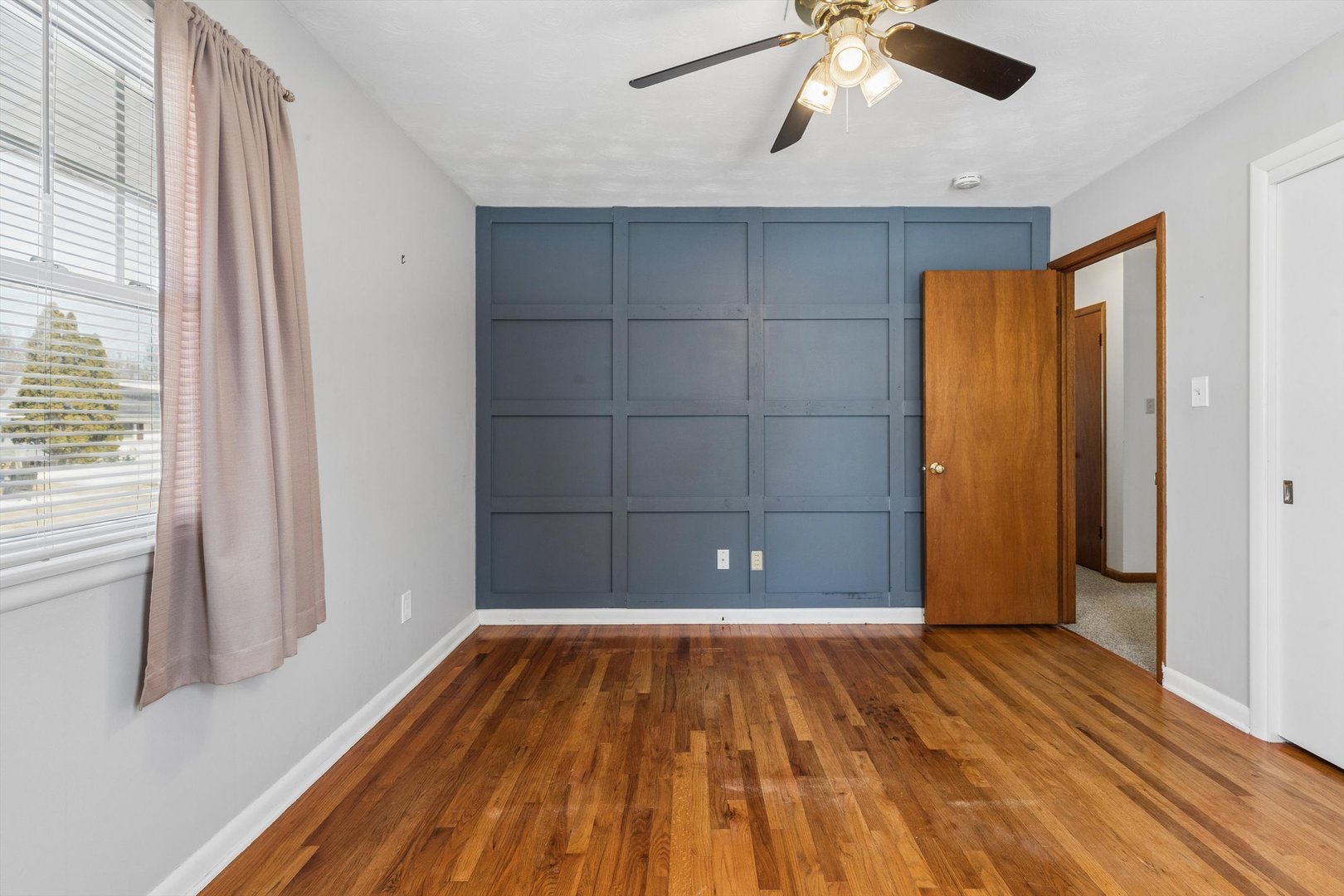 1245 8th Avenue North Clinton, IA 52732 - Photo 16 of 32 a view of a livingroom with wooden floor and a ceiling fan