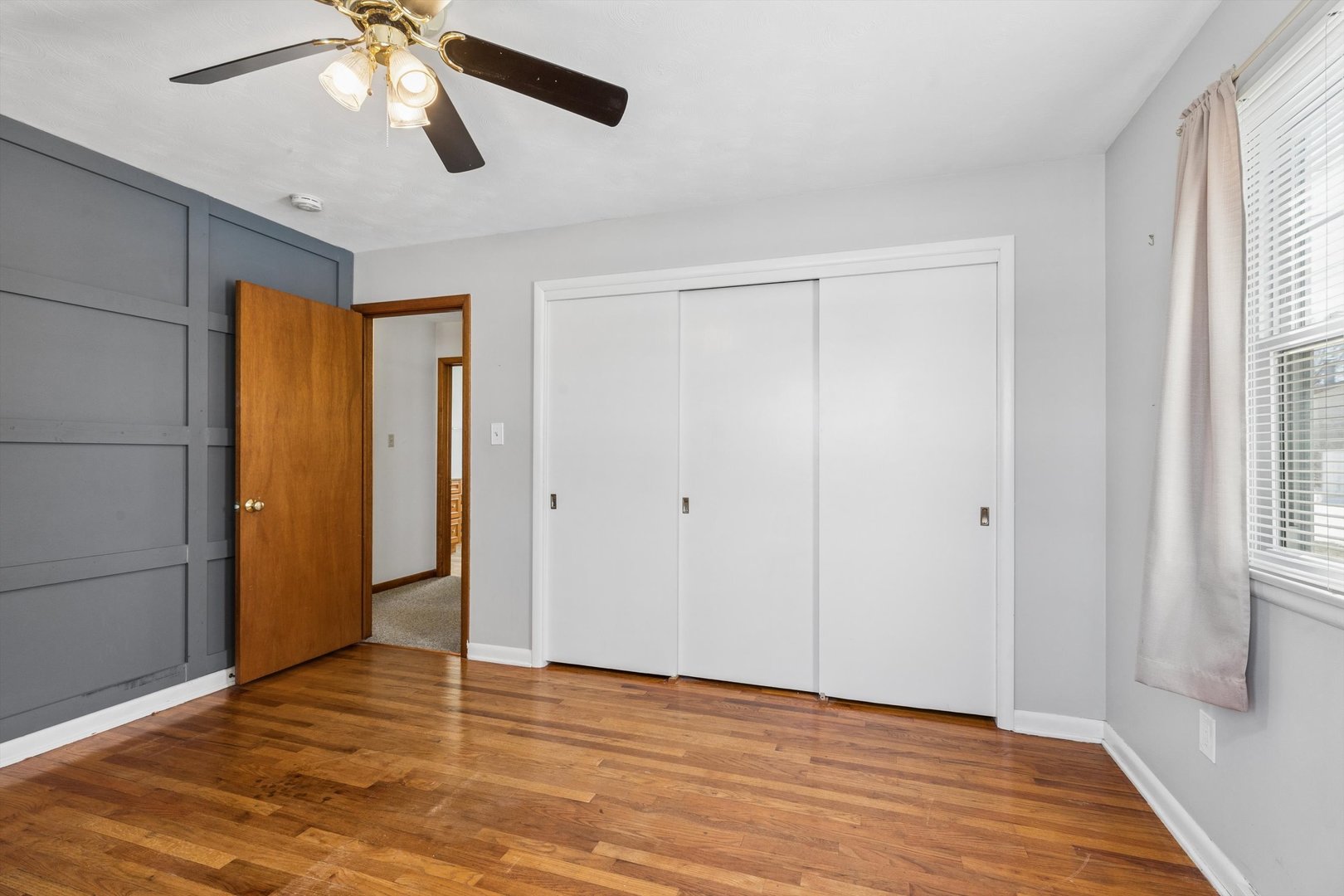 1245 8th Avenue North Clinton, IA 52732 - Photo 17 of 32 a view of an empty room with wooden floor and a window