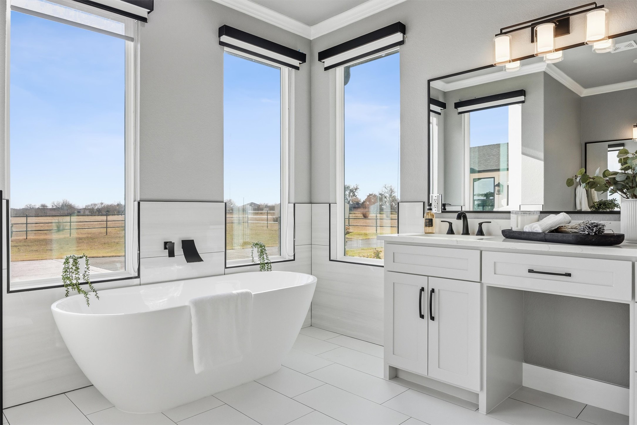 178 Balch Road Elgin, TX 78621 - Photo 13 of 40 Primary Bathroom featuring vanity, a soaking tub, quartz counter, ornamental molding, and light tile patterned flooring
