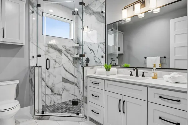 a bathroom with a sink a toilet and a mirror