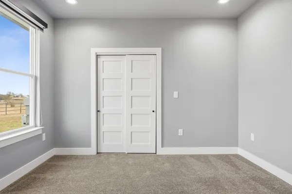 an empty room with windows and closet