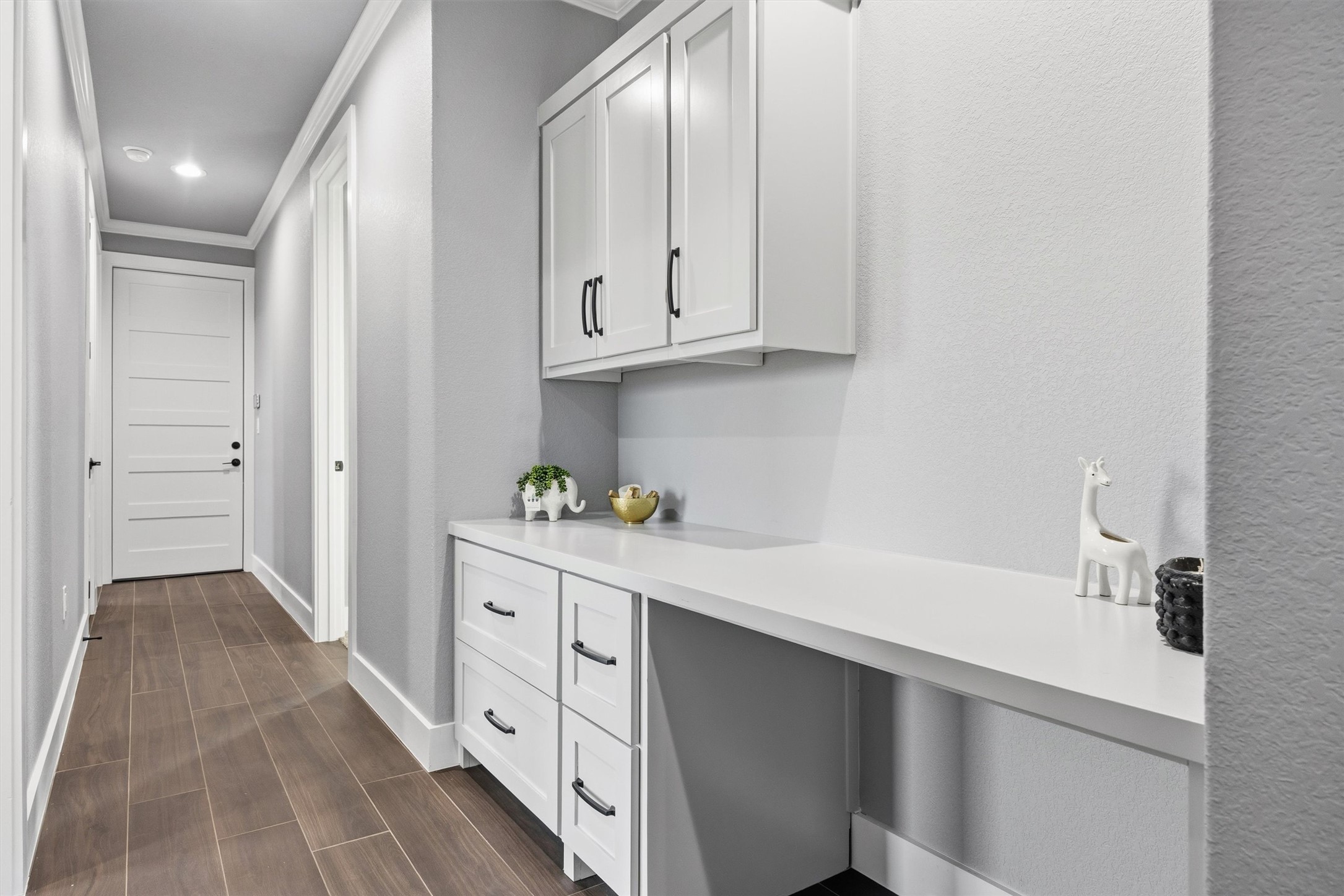 178 Balch Road Elgin, TX 78621 - Photo 24 of 40 Hallway featuring wood finish floors, crown molding, and recessed lighting, built ins and desk for office or kids desk.