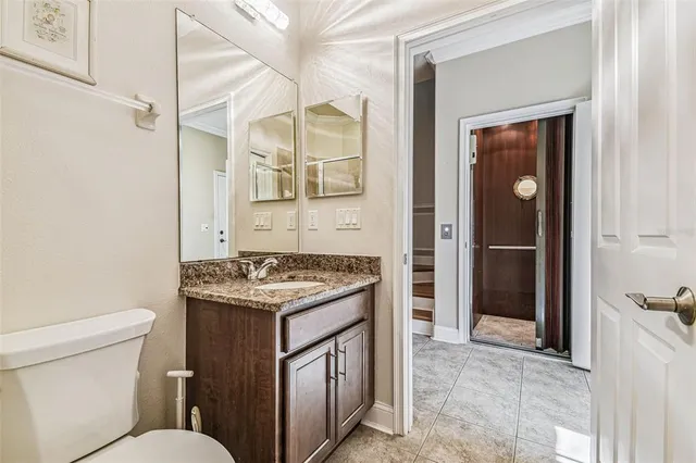 a bathroom with a granite countertop sink a toilet and shower