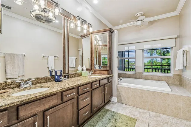 a bathroom with a granite countertop tub sink and mirror