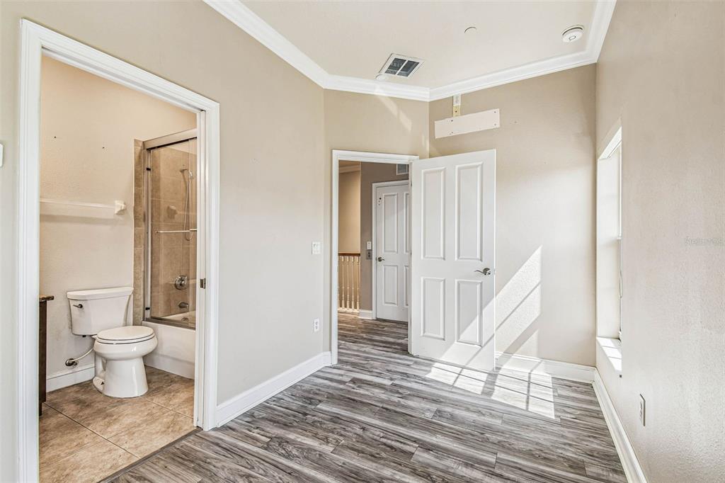 6533 Channelside Drive New Port Richey, FL 34652 - Photo 28 of 44 a view of a bedroom with wooden floor and a bathroom